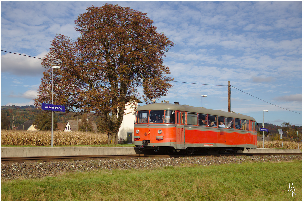 Der Schienenbus VT10.01 der Nostalgiebahnen in Kärnten auf seiner Abschiedsfahrt von der Rosentalbahn, festgehalten in Weitzelsdorf Ort. (22.10.2016)