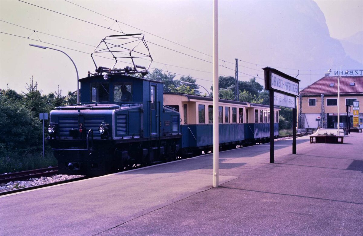 Der schöne frühere Beginn der Bayerischen Zugspitzbahn (BZB): Zug nach Grainau mit Tallokomotive 2 am Bahnhof Garmisch (Sommer 1984)