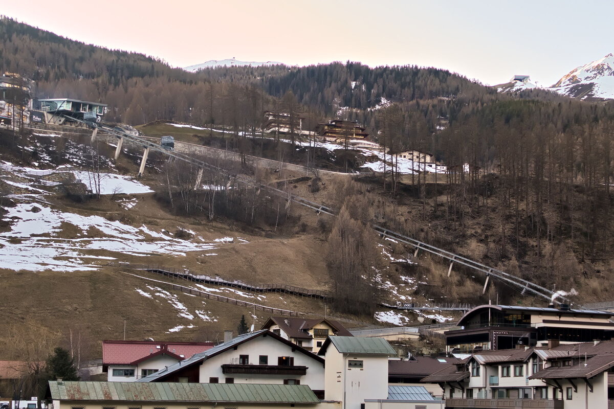Der Schrägaufzug  Zentrum Shuttle  in Sölden verbindet den Talboden an der Dorfstraße mit der höher gelegenen Unterwaldstraße. Überblick über die Strecke, aufgenommen vom Ufer der Ötztaler Ache aus. Foto vom 4.3.2025.