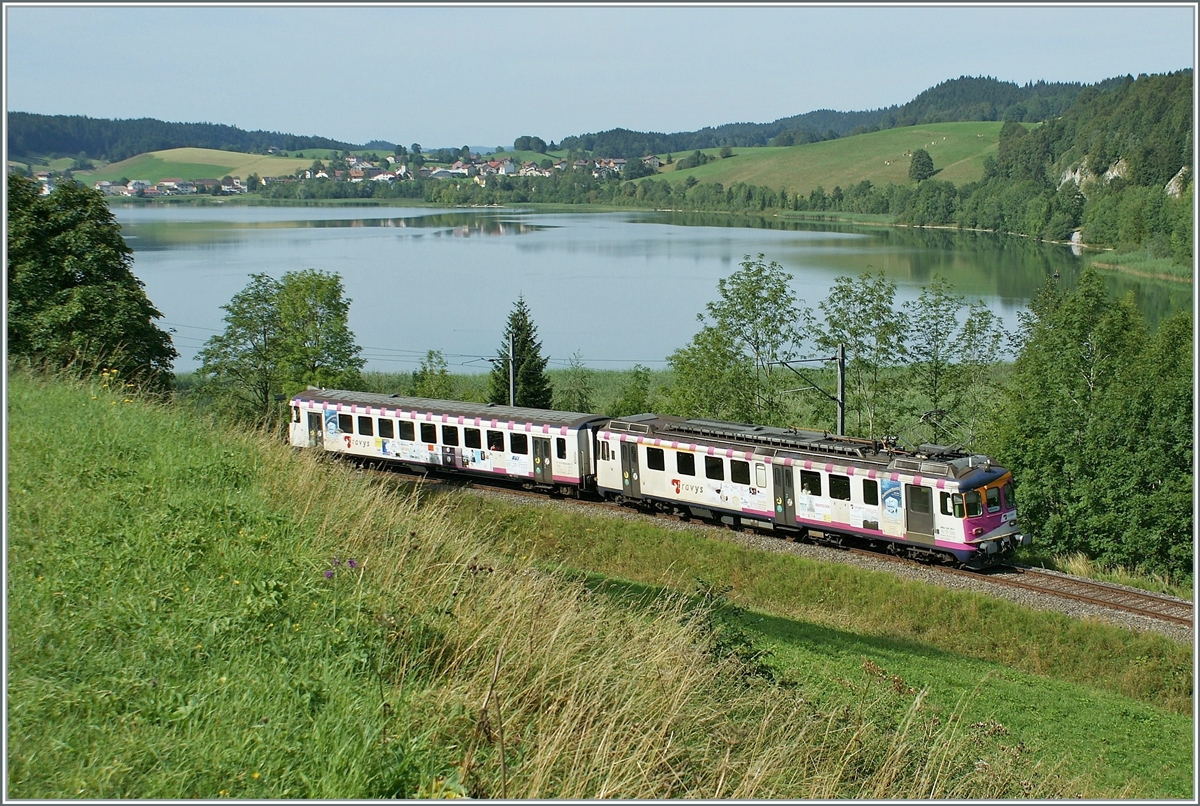 Der  Seehaas  ABDe (94 85 7)578 016-8 mit Bt 50 85 80-35 904-2, im Vallée de Joux auf der Fahrt von Le Brassus nach Vallorbe kurz nach Le Pont. 
Eigentlich fühlt sich der  Seehaas hier ganz wohl, gibt es doch, wie in seiner früheren Heimat  - und nur hier und dort - das seltene Seegras. (Quelle: Hinweisschild Hörnli, Konstanz) 

16. August 2009