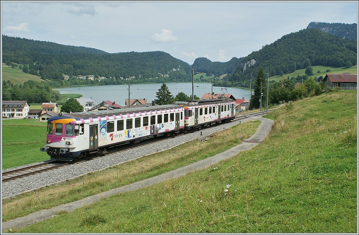 Der  Seehaas  Bt 50 85 80-35 904-2 mit dem schiebenden ABDe (94 85 7)578 016-8 im Vallée de Joux bei Les Charbonnières auf der Fahrt in Richtung Le Brassus. 
Eigentlich fühlt sich der  Seehaas hier ganz wohl, gibt es doch, wie in seiner früheren Heimat - und nur hier und dort - das seltene Seegras. (Quelle: Hinweisschild Hörnli, Konstanz)

16. August 2009