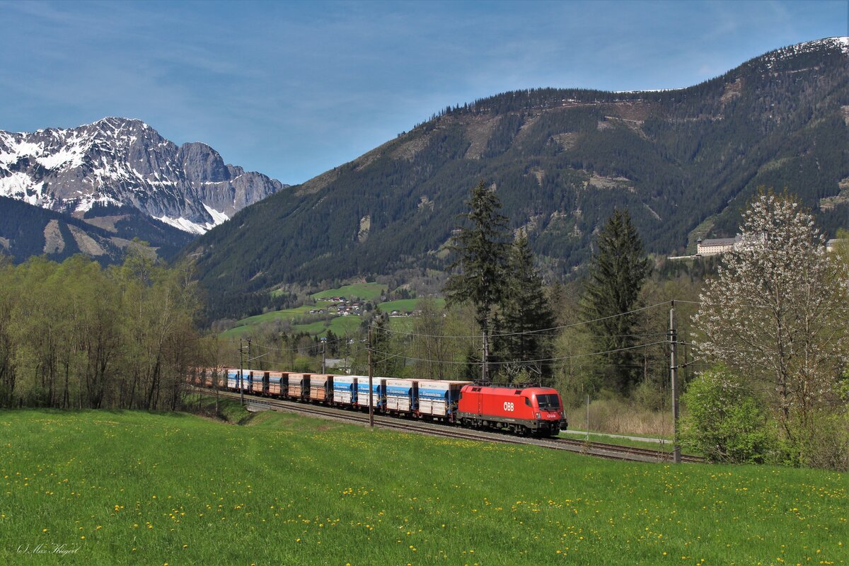 Der SGAG48444 von Jesenice nach Linz Stahlwerke fährt am 4.5.2023 bespannt mit der 1016 024 vor der gewaltigen Gebirgskulisse durch den Bahnhof Frauenberg an der Enns.