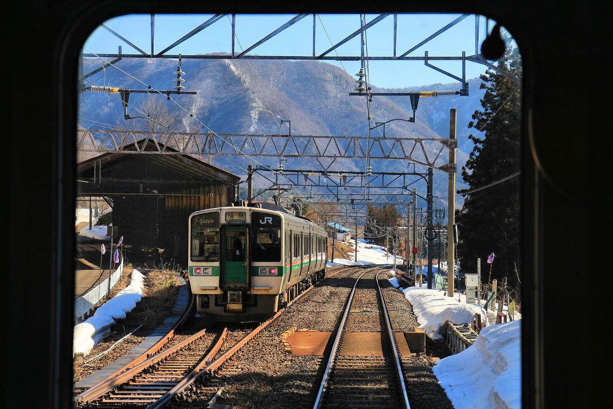 Der Shinkansen zum Hochplateau von Yamagata muss, um dorthin zu gelangen, eine ausserordentliche Steilrampe überwinden. Aufnahmen zu machen ist dort fast unmöglich, weil die Strecke durch tiefe Schluchten und finstere, auch von Bären bevölkerte  Wälder führt und praktisch nicht zugänglich ist. Die nur ganz spärlichen Regionalzüge ermöglichen wenigstens ein Bild durch die verglaste Führerstand-Rückwand von diesem fast nur von Shinkansen befahrenen Abschnitt. Hier kreuzt ein Regionalzug Serie 719 (Normalspur-Version Nr. 5010) in Itaya, der Zwischenstation der Steilrampe. 18.März 2019  