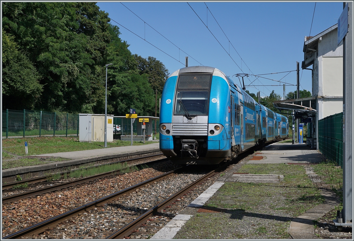 Der SNCF Doppelstocktriebzug Z 24368  Computermouse  ist in Richtung Grenoble unterwegs und fährt ohne Halt durch den kleinen Bahnhof von Pougny Changy. 

16. August 2021