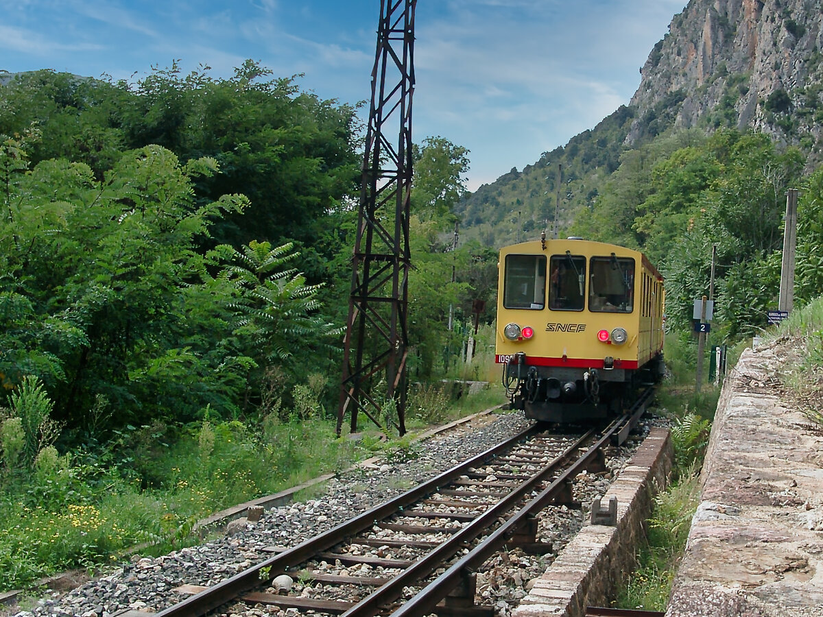 Der SNCF-Schmalspurtriebwagen 109 verlässt am 16.09.2002 den Bahnhof Villefranche-de-Conflent. Auf dem Bild unten rechts ist sehr gut die nicht abgedeckte Stromschiene zu erkennen.