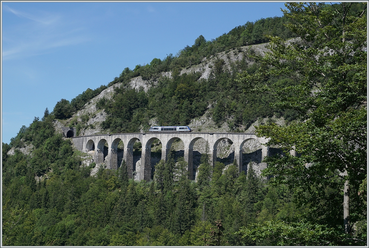 Der SNCF X 73657 ist als als TER 895511 von Dole nach St-Claude unterwegs und fährt auf dem Weg nach Morez über den aus zehn Bogen bestehenden und in einer langen Kurve liegenden 165 Meter langen Viaduc des Crottes. 

Da die Gegend stark bewaldet ist, war es nicht einfach eine geeignete Fotostelle zu finden. Doch die Streckenführung ist so faszinierend, dass ich mich schon jetzt auf eine weiteren Besuch freue und auch schon Ansätze für das Auffinden weiterer Fotostellen habe.

10. August 2021