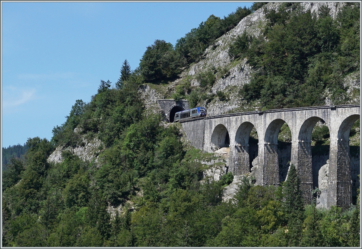 Der SNCF X 73657 hat den 69 Meter langen Tunnel des Crottes verlassen und fährt nun über den aus zehn Bogen und in einer langen Kurve liegenden 165 Meter langen Viaduc des Crottes.
Der Dieseltriebwagen ist als TER 895511 von Dole nach St-Claude unterwegs.

10. August 2021