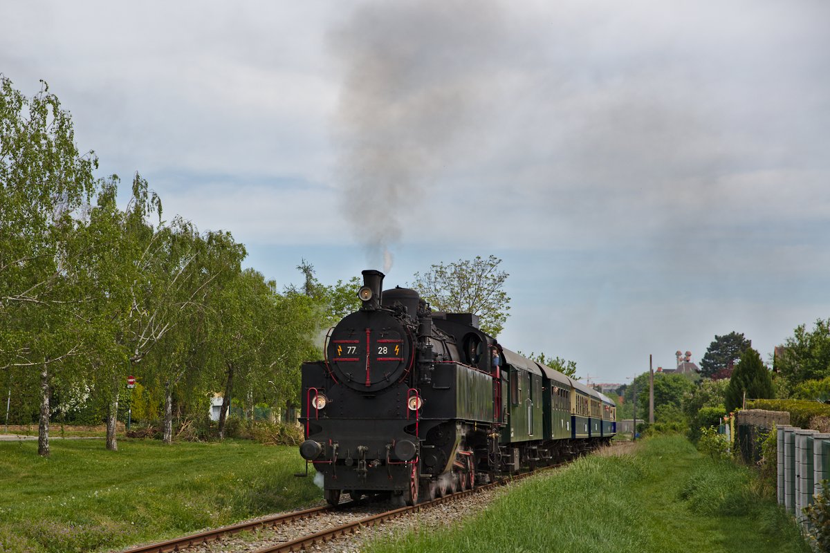 Der Sonderzug bespannt mit der 77.28 kurz nach Verlassen des Bahnhofs Wien Liesing.
Die zwei Handymasten im Hintergrund wurden übrigens herausretuschiert. (01.05.2018)