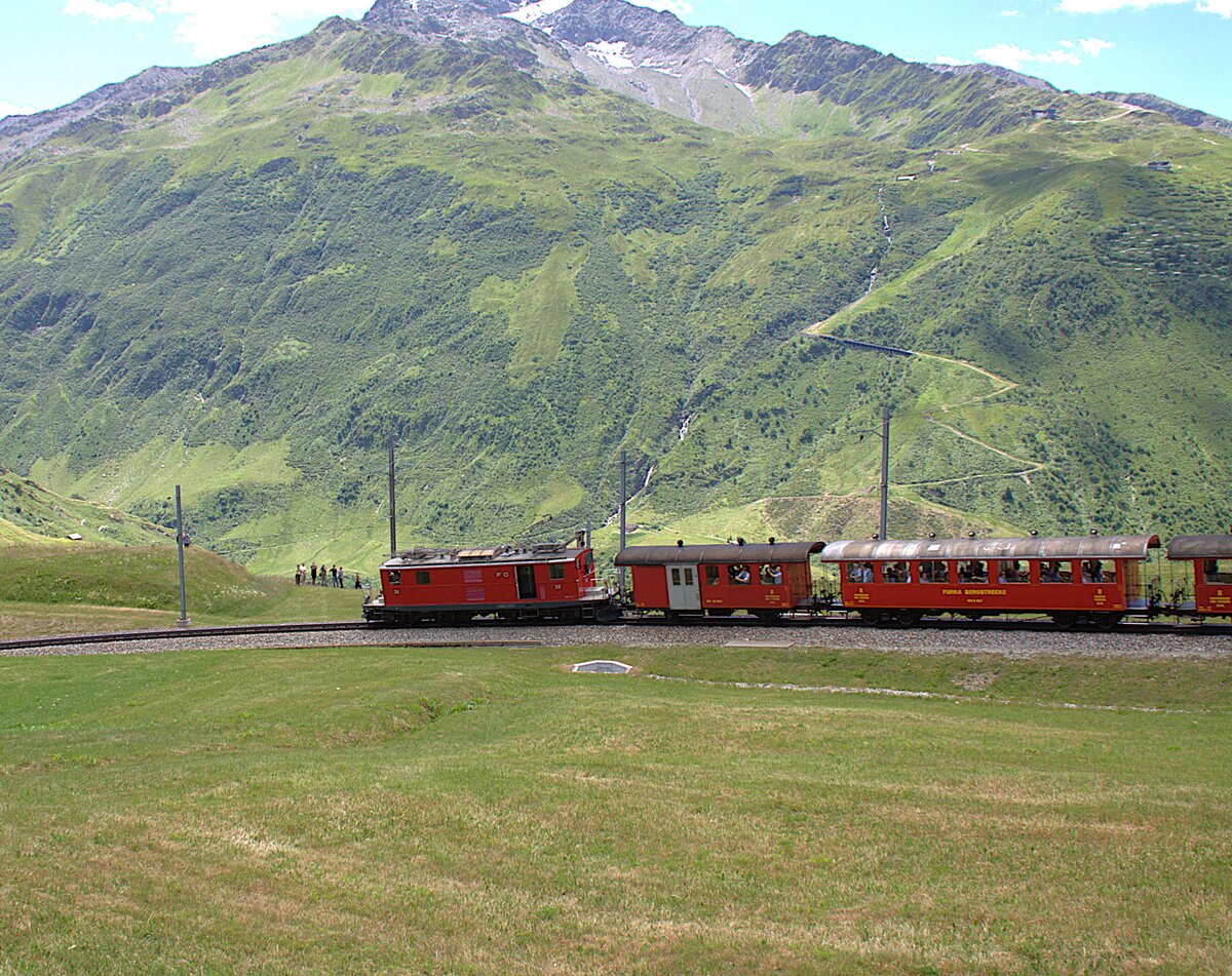 Der Sonderzug zum Jubil�um 100 Jahre FO hat am 05.07.2026 die Station N�tschen verlassen und f�hrt jetzt Richtung Andermatt.
Im Hintergrund ist der Gemsstock samt Seilbahn zu erkennen.