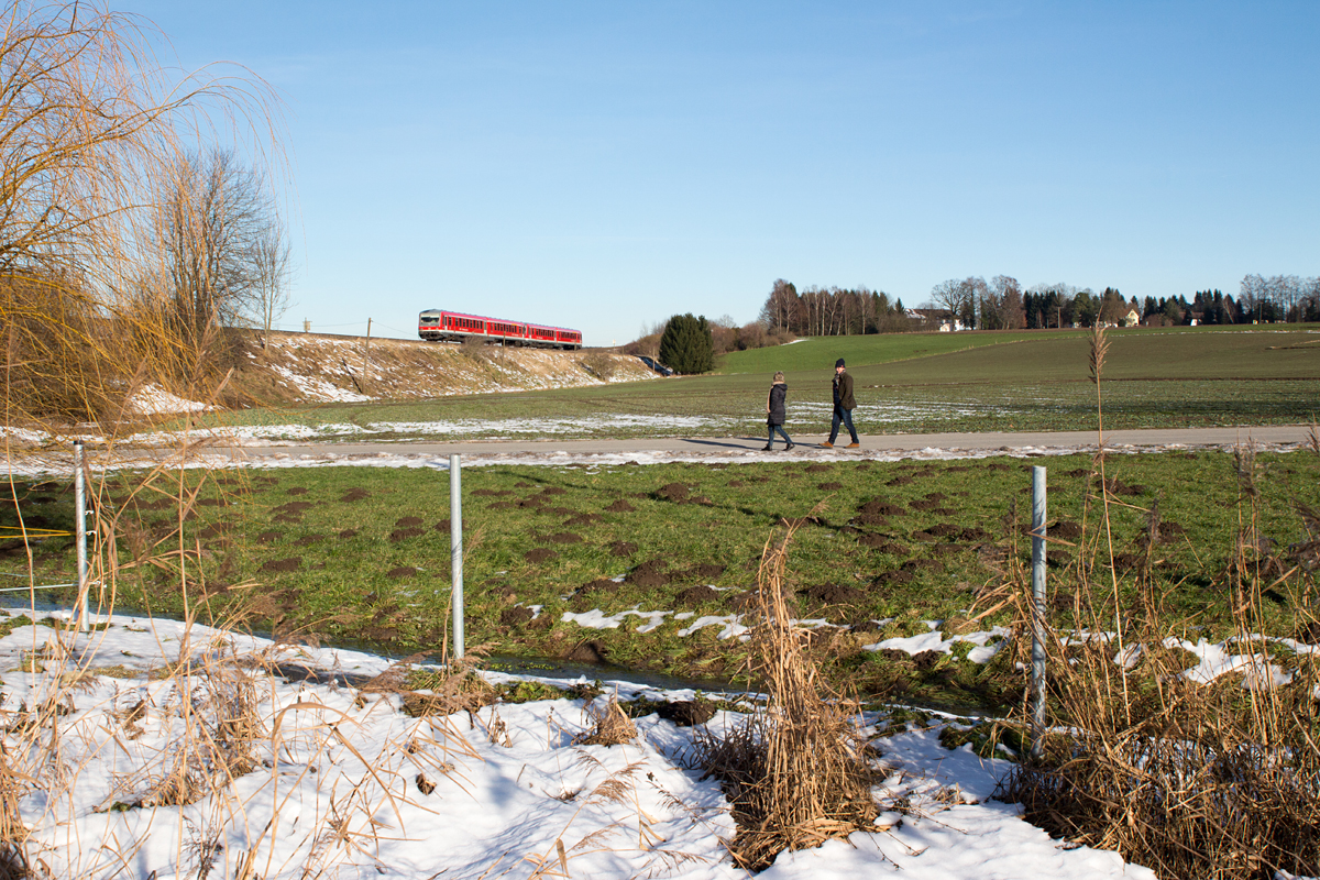 Der sonnige  Drei-Königstag  in Bayern lockte einige Menschen zu einem Spaziergang in die Natur. Ein 628 fährt nebenbei bei Ottenhofen gerade in Richtung Mühldorf.