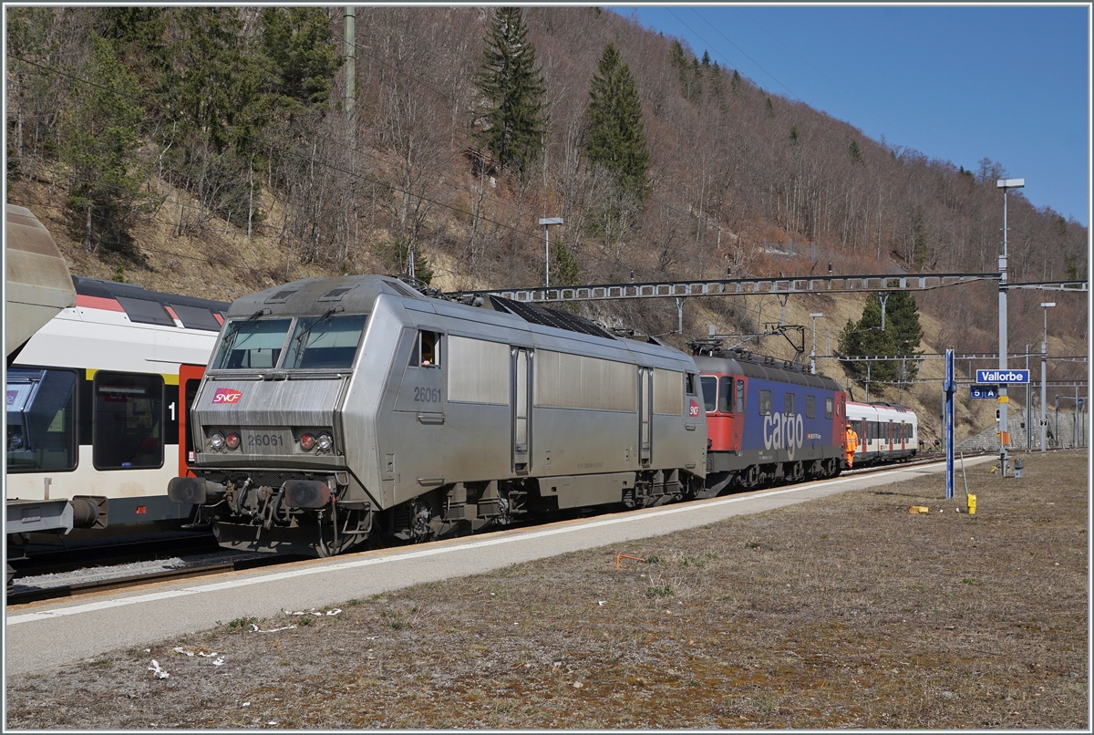 Der  Spaghetti -Zug der Gegenrichtung ist in Vallorbe angekommen und die abgebügelte SNCF Sybic BB 26061 wird von der SBB Re 6/6 11615 (Re 620 015-8) rangiert. 

24. März 2022