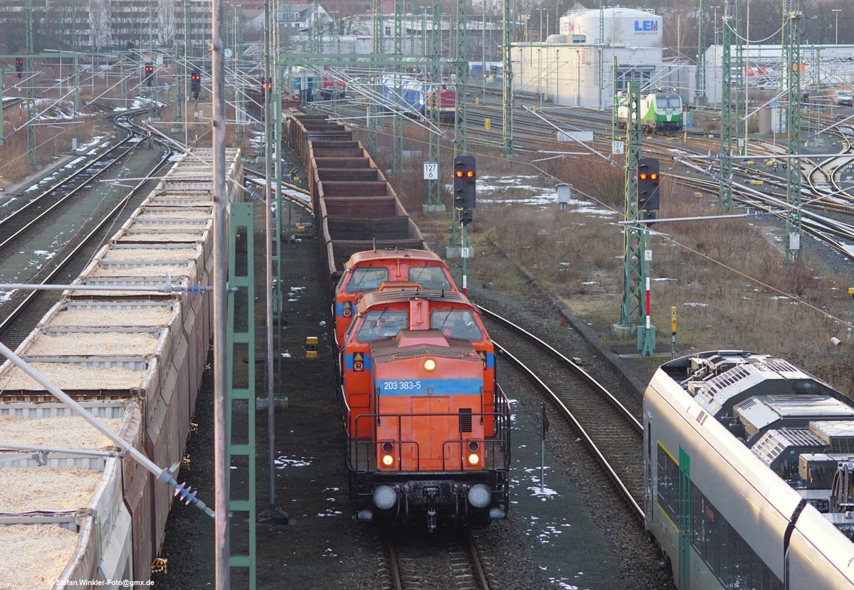 Der Stahl-/Schrottzug des Stahlwerks Thüringen auf Durchfahrt durch Hof Hbf am 12.02.2018 mit zwei DR V 100. Ringsum der Alltag in Hof, inkl. eines Hackschnitzelzuges links, der sicher nach Wiesau ging (oder von dort kam)...