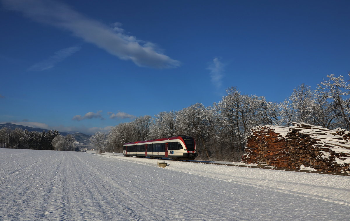 Der Stahlblaue Himmel brachte Klirrende Kälte mit sich . 
Am Morgen des 10.Dezember 2017 hatte es im Sulmtal gerade mal 12,5 Grad Minus. 
Hier bei Dietmannsdorf strahlt der GTW 2/8 ( R8555 ) daher. 

