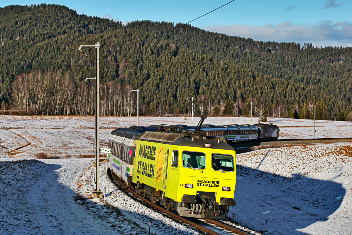 Der  Staubsauger  Re 456 018  Akademie St.Gallen  schiebt am Voralpenexpress der geführt vom  Staubsauger  Re 456 017  Ein Hauch Fernweh  auf dem Weg nach St.Gallen bei Altmatt vorüberfährt.Bild vom 5.1.2016