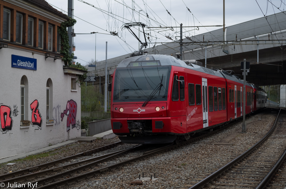Der SZU Be 516 durchfährt mit in Doppeltraktion mit einem Artgenossen am 11. April 2015 Zürich Giesshübel auf seinem Weg auf den Uetliberg. Hier gut zu sehen der seitlich angeordnete Stromabnehmer. Dies ist nötig, weil sich die mit 1200V Gleichstrom elektrifizierte Uetlibergbahn das Gleis zwischen Zürich HB und Zürich Giesshübel teilweise mit der mit 15kV Wechselstrom elektrifizierten Sihltalbahn teilt. Die neuen Stadler-Züge besitzen verschiebbare Pantographen und eine Zweistromausrüstung, damit ein Einsatz auf beiden Strecken möglich ist. Derzeit kommen sie aber wie hier fast ausschliesslich auf der Uetlibergbahn zum Einsatz.