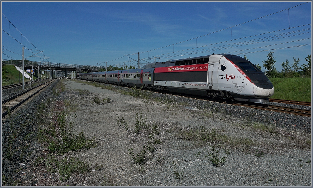 Der TGV Lyria 9203 von Paris Gare de Lyon nach Zürich erreicht Belfort-Montbéliard TGV. Der TGV Lyria Triebzug 4409 wirbt mit seinem Botschafter Stan Wawrinka für die Marke Lyria. 

Ob der Botschafter sich freut, künftig bei gewissen Verbindungen von Lausanne nach Paris länger unterwegs zu sein als heute? 

1. Juni 2019