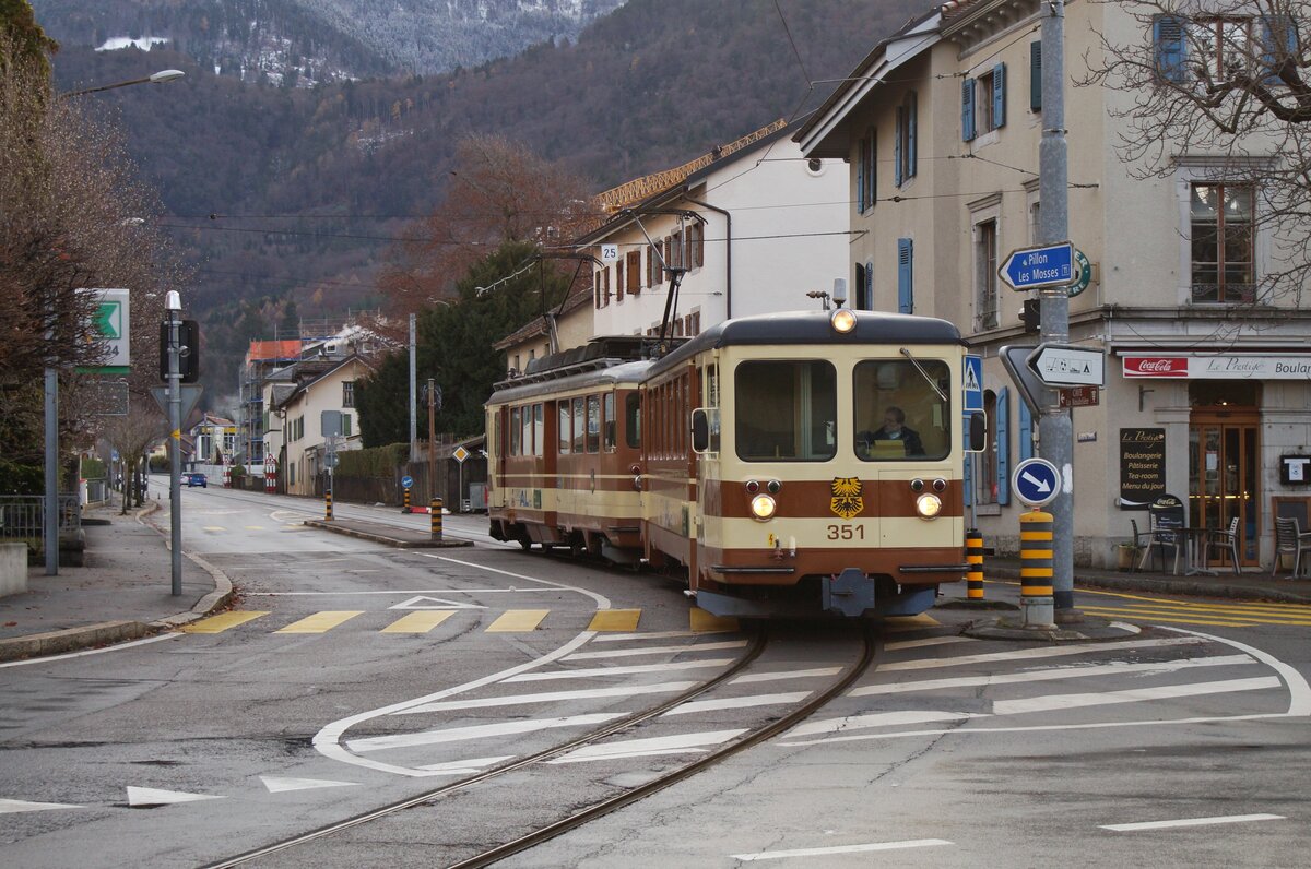 Der TPC A-L Regionalzug 329 von Leysin nach Aigle bestehet aus dem Bt 351 und dem BDeh 4/4 302. Der Zug hat den Halt Aigle-Place-du-Marché verlassen und überquert nun eine Kreuzung um dann durch die Altstadt zum Bahnhof von Aigle zu kommen. 

5. Dezember 2021