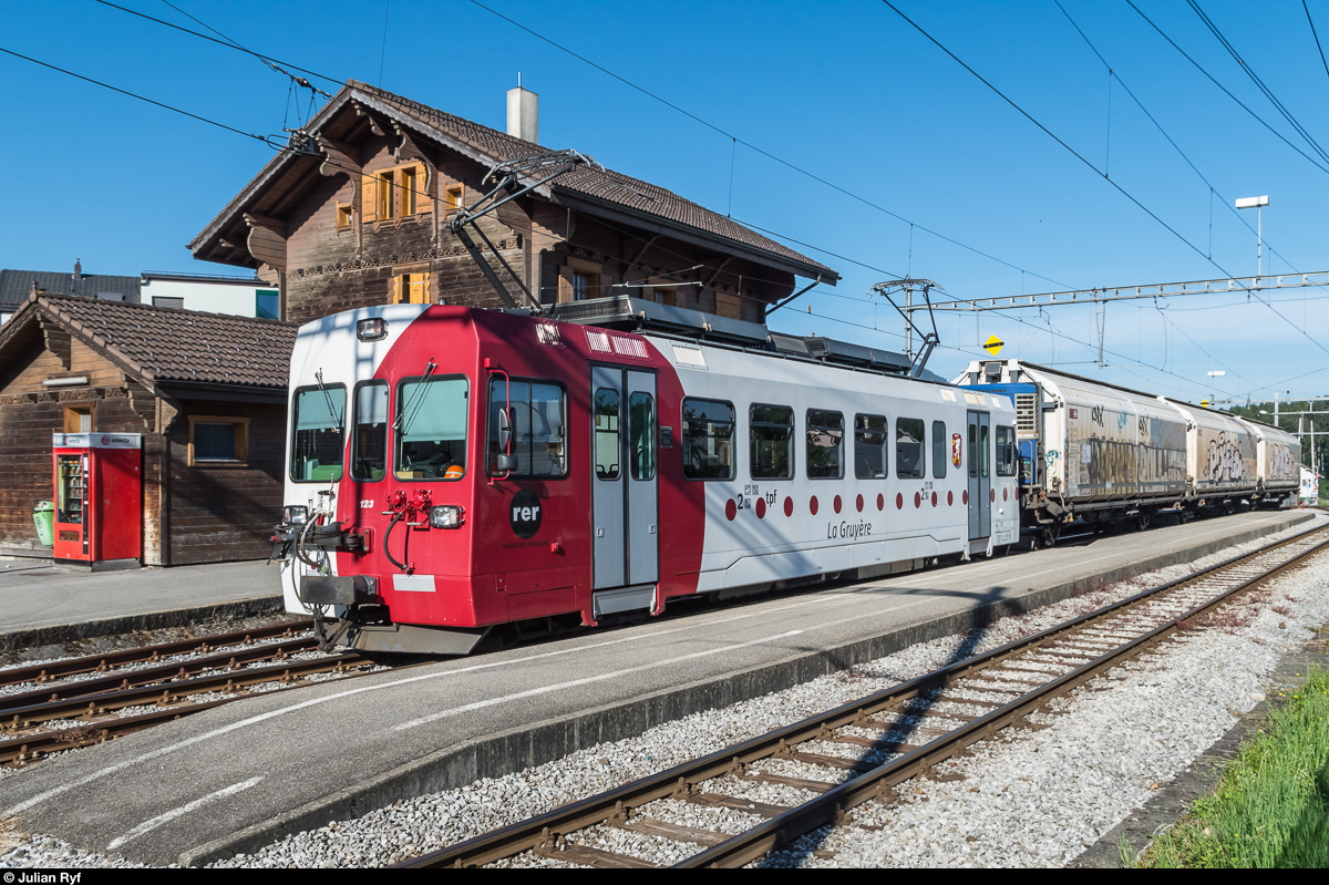 Der TPF Be 4/4 123 erreicht am 7. Juli 2016 mit einem Rollbockzug den Bahnhof Broc Village, wo die Kreuzung mit dem Regionalzug abgewartet wird.