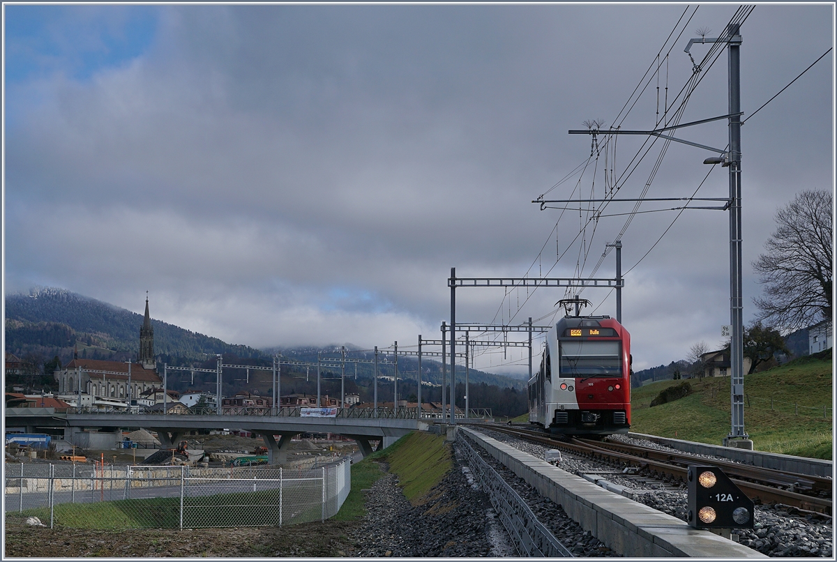 Der TPF SURF Be 2/4 - B -ABe 2/4 105  L'armayi  erreicht als S50 von Palézieux kommend kommend den neuen Bahnhof von Châtel-St-Denis.
Standpunkt des Fotografen: auf dem Grünstreifen zwischen Strasse und Bahn

28. Dez. 2019