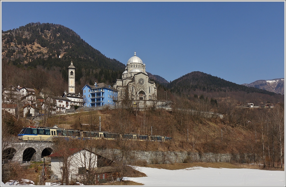 Der Treno Panoramico 40 von Locarno nach Domodossola fährt an der prächtigen Kirche Madonna del Sangue in Re vorbei.
(19.03.2015)
