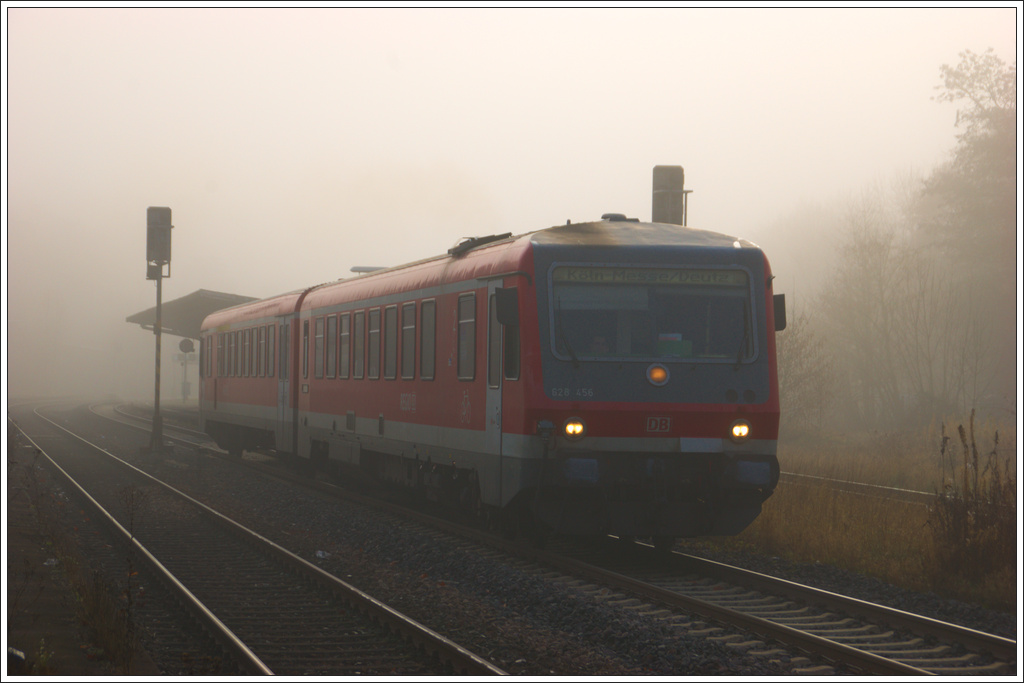 Der Triebzug 628 456 ist unterwegs nach Köln-Messe/Deutz als er den nebligen Bahnhof Bitburg-Erdorf verlässt am 19. November 2011.