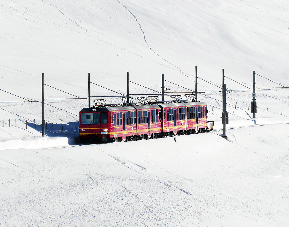 Der Triebzug der Jungfraubahn hat vor ein paar Minuten die Station Kleine Scheidegg (2061 müM) verlassen und fährt mitten im Schnee nach Eigergletscher. Kleine Scheidegg, 11.1.2024