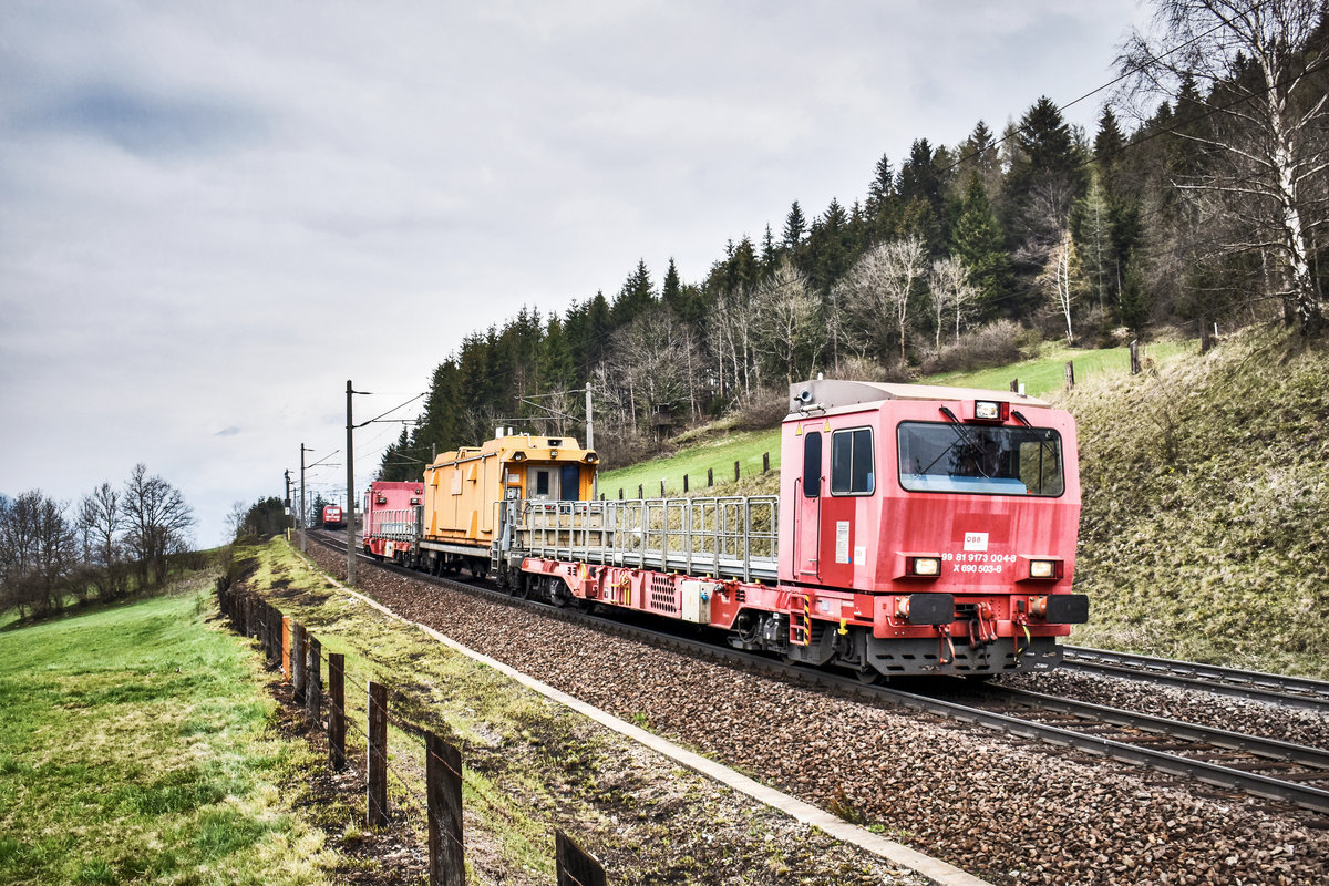 Der Tunnelrettungszug, mit X 690 503-8 an der Spitze, fährt auf dem Weg nach Spittal-Millstättersee, bei Penk, die Tauernbahn-Südrampe hinunter.
Im Hintergrund der Richtung Dortmund fahrende EC 114  Wörthersse .
Aufgenommen am 13.4.2019.