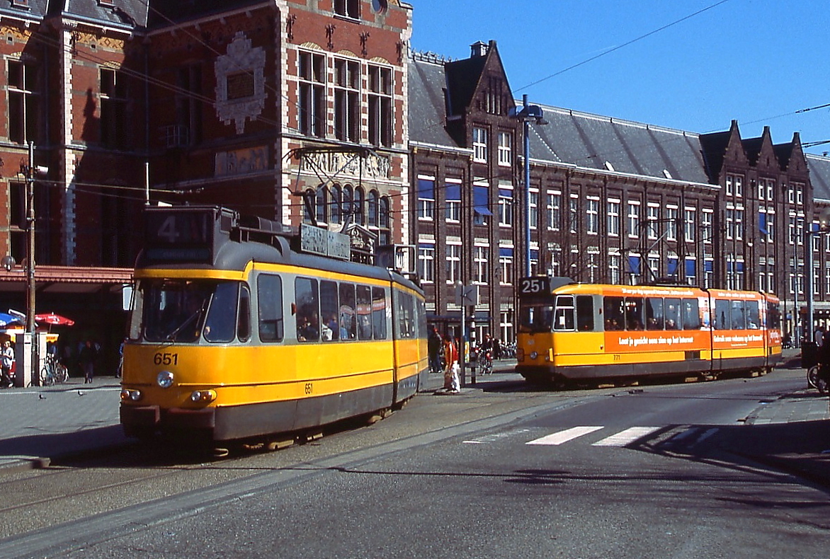 Der Typ 4/5G der Amsterdamer Tram wurde im Anschluss an den Typ 3G bis 1964 beschafft. Im April 2002 verlässt 4/5G 651 die Haltestelle am Hauptbahnhof, im Hintergrund der 8G 771. Beide Fahrzeuge sind noch in der in den 1970er Jahren eingeführten schwarz-gelben Farbgebung lackiert, die ab Ende der 1990er Jahre durch blau-weiss ersetzt wurde.