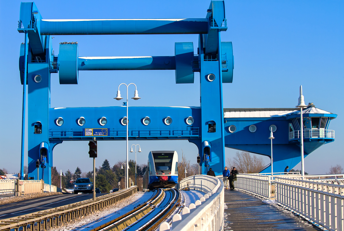 Der UBB Triebwagen fährt über die Wolgaster Peenebrücke bis Swinemünde Centrum. Die -9 °C scheinen Angler und eine Schar Tauben auf der Brücke zum Sonnen zu nutzen. - 24.01.2014
