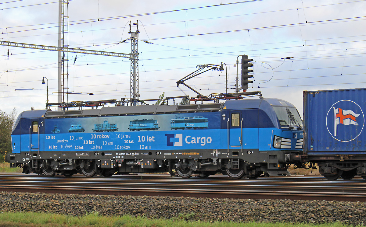 Der Vectron 383 004 von CD Cargo wartet am 08.10.2017 am Ausfahrsignal eines der
Mělníker Gütergleise auf Grün. Ein Glück, dass die Maschine so groß ist, da passt dann doch eine ganze Menge mehr Werbung drauf.