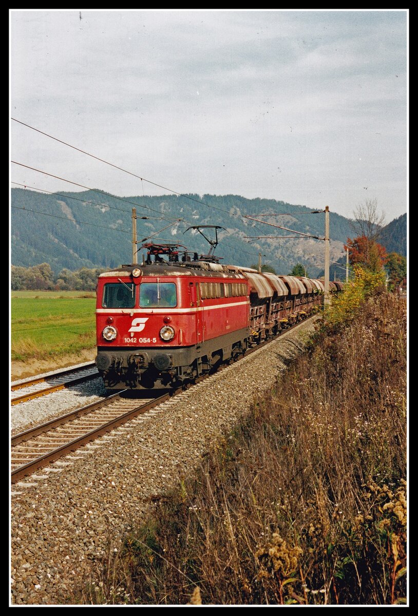 Der Verkehr von der Anschlussbahn der Hartsteinwerke Perg in den Bahnhof Fentsch St.Lorenzen werden als Nebenfahrten abgewickelt. 1042 054 ist am 16.10.2001 mit einer Fuhre Gleisschotter auf besagtem Streckenstück unterwegs.