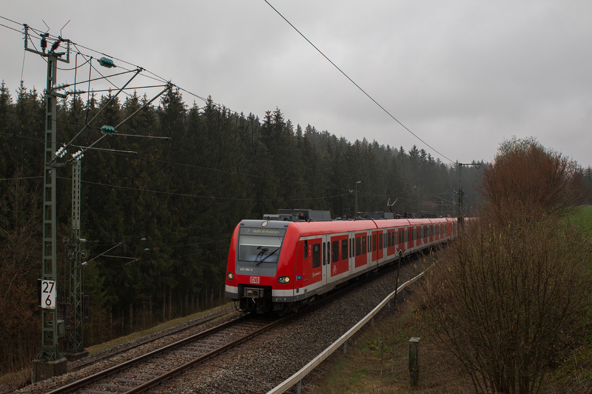 Der Vormittag des 09.04.16 war in Oberbayern von Nieselregen geplagt.
Dies hielt mich jedoch nicht davon ab, 423 064-5 als S7 nach Wolfratshausen bei der Ausfahrt aus dem Bahnhof Kreuzstraße zu fotografieren. Er hatte an dieser Stelle eine respektable Steigung zu bewältigen.