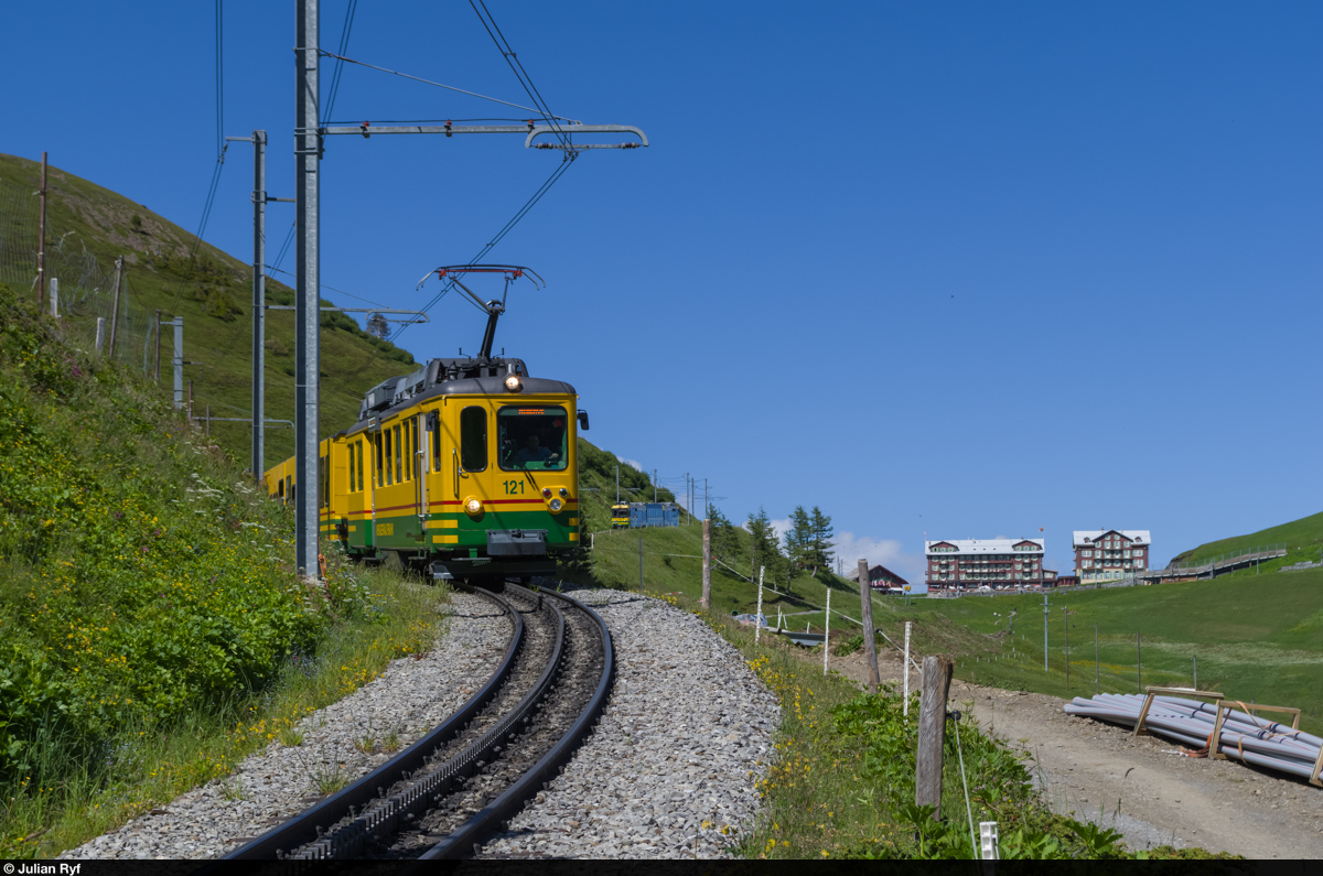 Der WAB BDhe 4/4 121 fährt am 24. Juni 2015 unterhalb der Kleinen Scheidegg talwärts in Richtung Lauterbrunnen. Ein paar Hundert Meter weiter hinten folgt mit Pano 149 der neuste Zug der WAB, abgeliefert ca. Anfang Mai 2015.