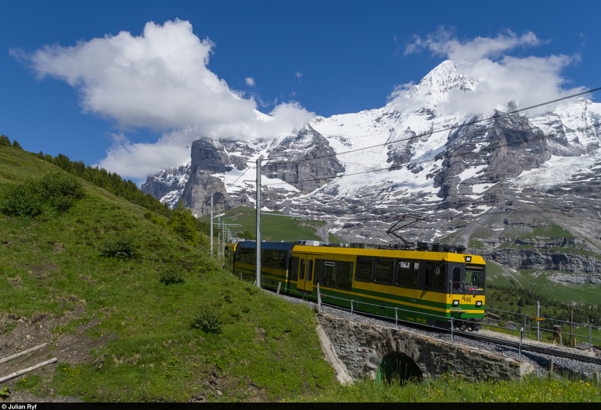 Der WAB Pano 146 fährt am 24. Juni 2015 etwas oberhalb der Wengernalp talwärts. Im Hintergrund die von Wolken verdeckten Eiger und Mönch.