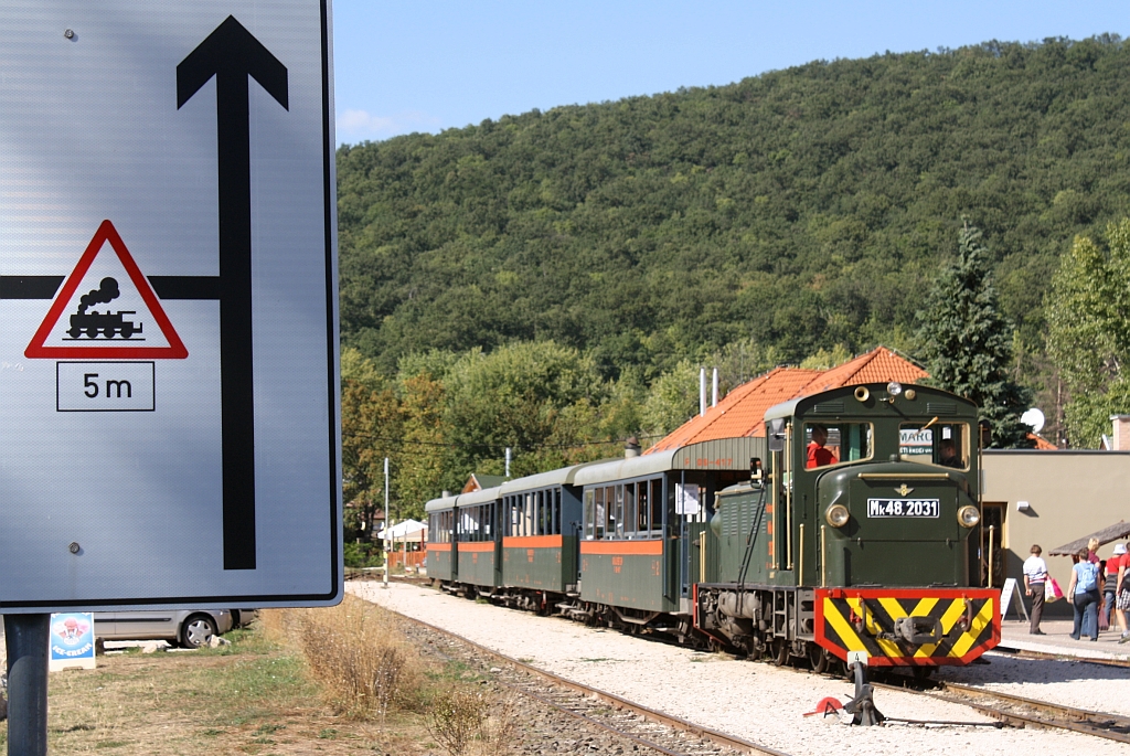 Der Weg zur Bahn; im Hintergrund die Mk48.2031 der Kirlyrti Erdei Vast mit Zug 6303 am 07.September 2013 im Bf. Kismaros.