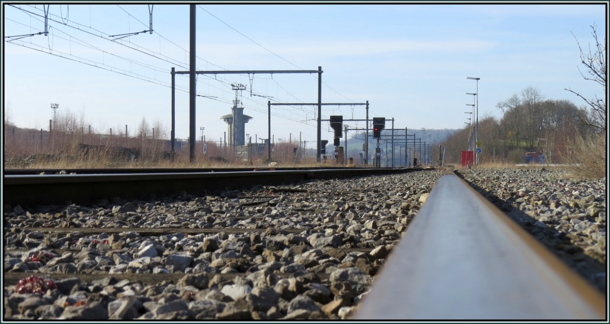 Der weite Blick hinein auf den Güterbahnhof von Montzen in Belgien. Das futuristische Gebäude im Hintergrund ist das Stellwerk des einst so wichtigen Umschlagbahnhofs für Güter im Grenzgebiet NL,B,D.Heute fahren die meisten Züge direkt durch ,ohne Lokwechsel.Szenario vom März 2014.