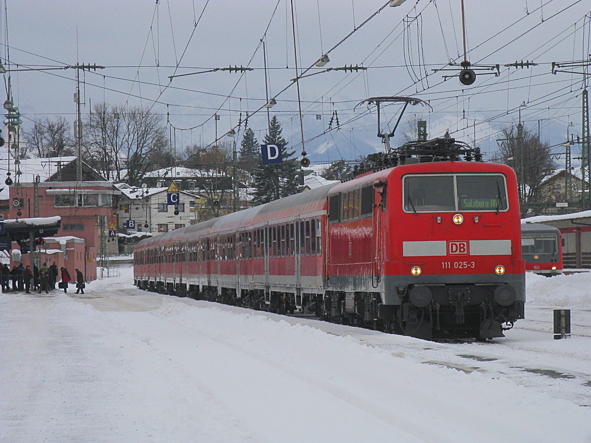 Der Winter 2011/2012 war in Südbayern schneereich. So auch am 17. Februar 2012, als Lok 111 025 mit einer Regionalbahn nach Salzburg in Traunstein auf Abfahrt wartet.