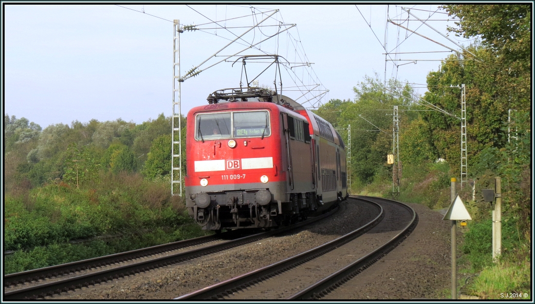 Der Wupper Epress (RE4) mit der 111 009-7 als Zugpferd ist unterwegs nach Aachen auf der Kbs 485. Hier zu sehen am BÜ bei Rimburg am 10.Oktober 2014.