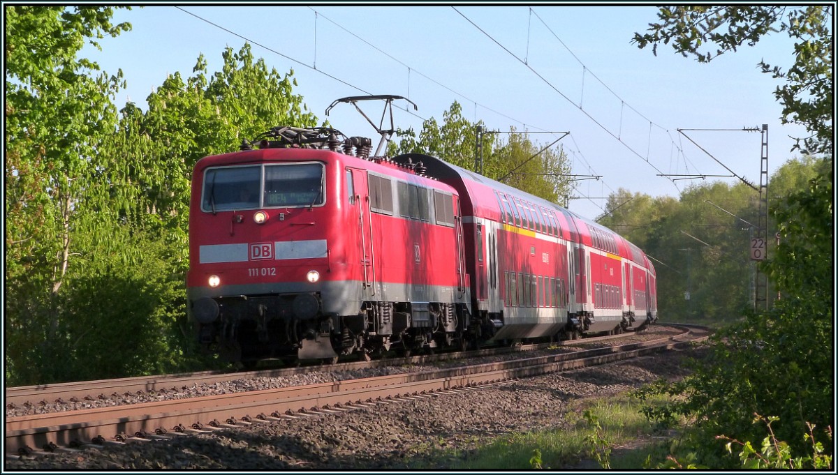 Der Wupperexpress (RE 4) ist unterwegs nach Aachen. Hier zu sehen im Gleisbogen bei Rimburg auf der Kbs 485 im April 2014. Als Zugpferd dient die 111 012.