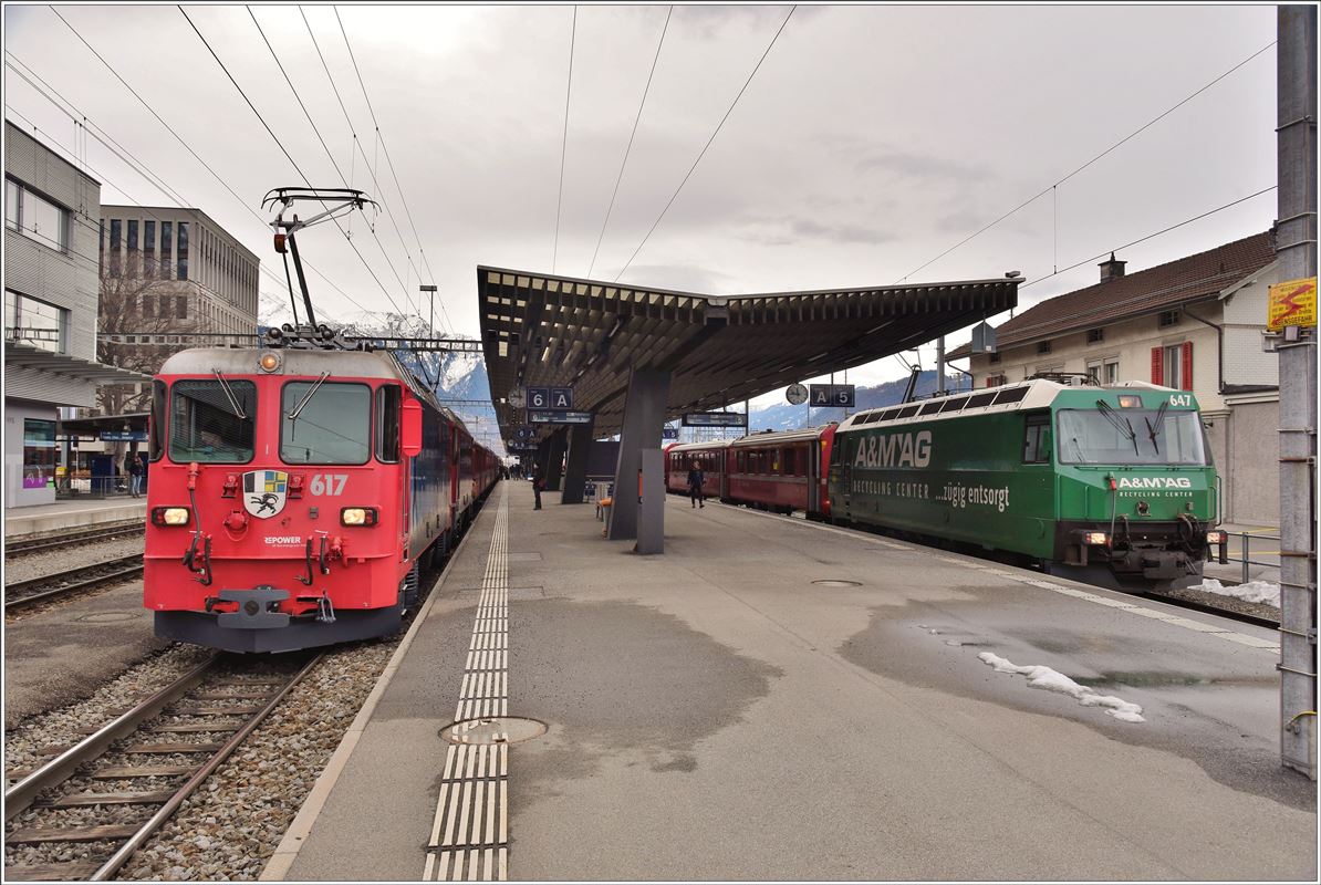 Der Zehn Wagen Zug RE1728 erhält zwei Ge 4/4 II 617  Ilanz  und 614  Schiers . Daneben steht RE1037 nach Davos Platz mit Ge 4/4 III 647  Grüsch  abfahrbereit in Landquart. (04.02.2017)