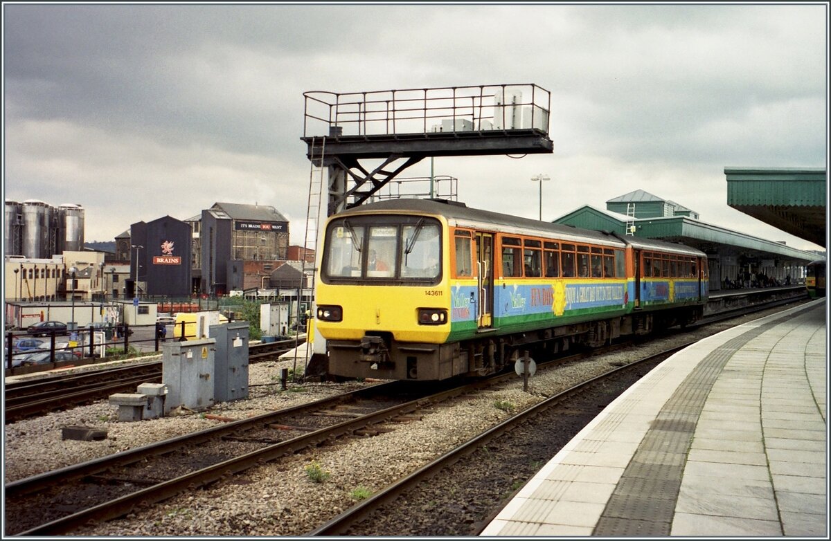 Der ziemlich bunte Class 143 Triebzug 143 611 verlässt Cardiff Central /Caerdydd Canolog . 

Analogbild vom 7. November 2000