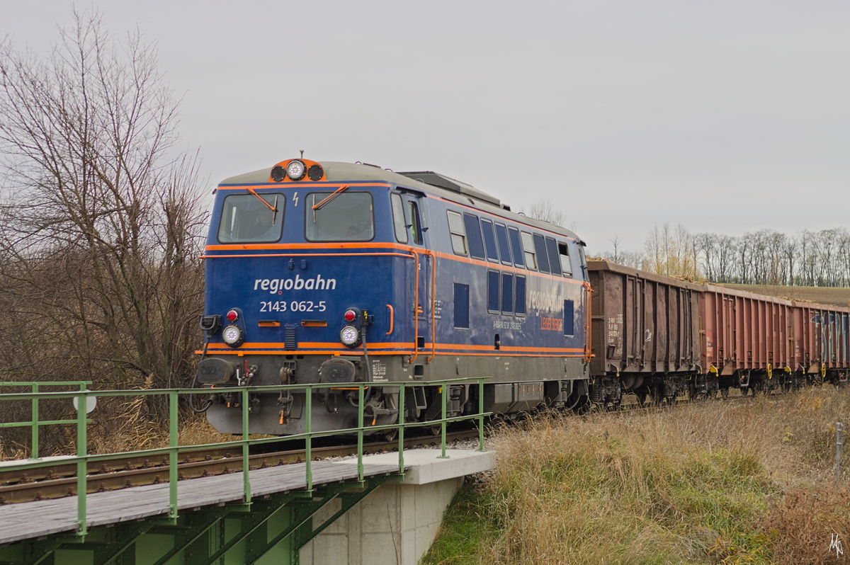 Der Zufall wollte es, dass ich am 20.11.2021 die 2143.062 mit einem Rübenzug bei der Ausfahrt vom Ladeplatz Paaasdorf vor die Linse bekam.
