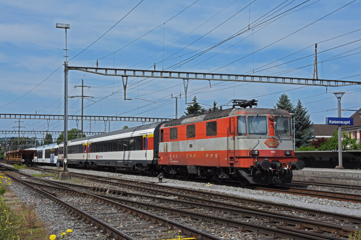 Der Zug ist beim Bahnhof Kaiseraugst angekommen. Nun wird die Re 4/4 II 11114 und ein erste Klasse Personenwagen abgekoppelt. Danach kommt der Tm 232 310-3 der Firma Thommen und wird an die Re 4/4 II 11109 angekuppelt. Die Aufnahme stammt vom 28.06.2021.