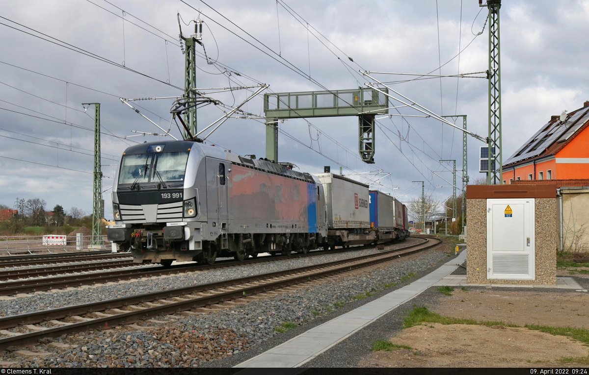 Der zweimonatige Umleiterverkehr gipfelte vom 9. bis 15. April in einer Vollsperrung in Bad Kösen, wo vier zusätzliche Weichen als Vorbereitung der Sanierung der Saalebrücken eingebaut wurden. So musste die Kasseler Schiene etliche Güterzüge der Thüringer und Saaletalbahn aufnehmen.
Einer ihrer Vertreter war ein KLV-Zug, der mit 193 991-7 (Siemens Vectron) just den Bahnhof Angersdorf Richtung Halle (Saale) durchquert hat und auf Höhe des ehemaligen Fahrdienstleiter-Stellwerks fotografiert wurde.

🧰 Railpool GmbH, aktueller Mieter unbekannt
🕓 9.4.2022 | 9:24 Uhr