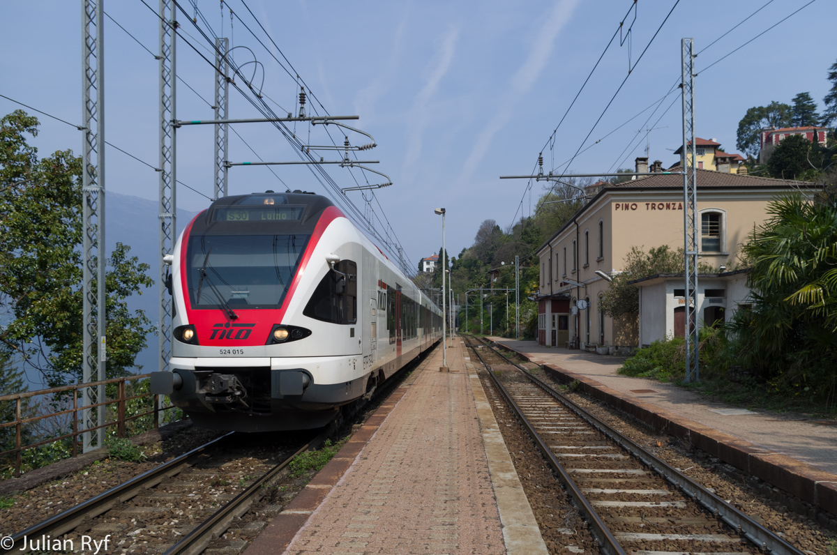 Der Zweisystem-FLIRT RABe 524 015 hält am 10. April 2015 im Bahnhof Pino-Tronzano, der ersten Station auf Italienischem Boden auf seinem Weg nach Luino. Die S30 verkehrt im Zweistundentakt(!), wobei die meisten Züge bis zum Aeroporto Milano-Malpensa durchgebunden werden. Trotz des nur wenigen Personenverkehrs (sowohl auf Italienischer wie auch auf Schweizerischer Seite gibt es noch eine parallele Buslinie, welche die Orte besser erschliesst), ist der Bahnhof nach wie vor bedient. Wahrscheinlich liegt das aber daran, dass es hier oft zu Kreuzungen mit Güterzügen kommt. 