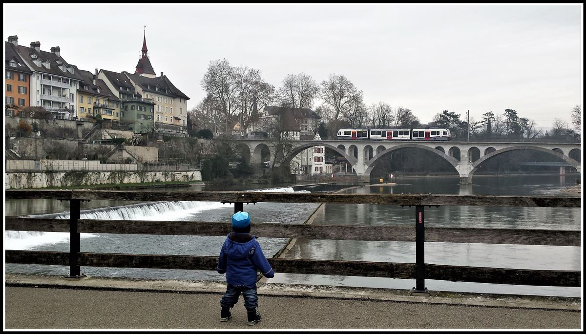 Diamant ABe 4/8 von Stadler Rail überquert die Reuss in Bremgarten, beobachtet von einem kleinen Fan. (19.12.2018)