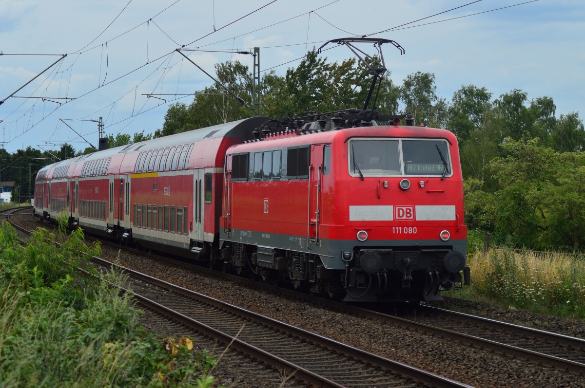 Die 111 080 schiebt am Sonntag den 26.7.2015 bei Kaarst einen RE7 nach Krefeld.