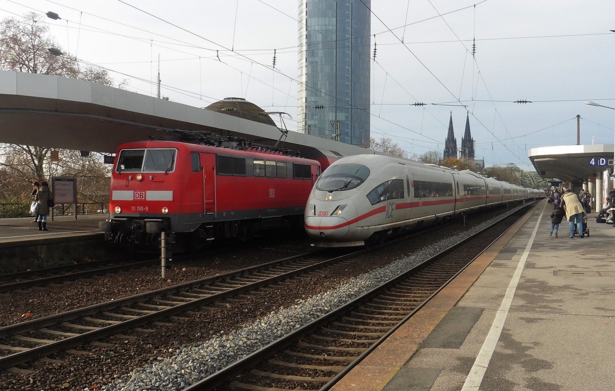 Die 111 150-9 der DB mit RE 7 (Krefeld - Rheine) beim Halt und ICE 3 bei der Durchfahrt in Köln Messe/Deutz , DEN 05.12.2015