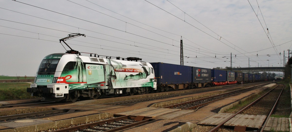 Die 1116 130-6 ``10 Jahre E-Card`` modern, schnell, sicher ist am 27.11.2014 mit einem Containerzug durch Kirchstetten unterwegs. 