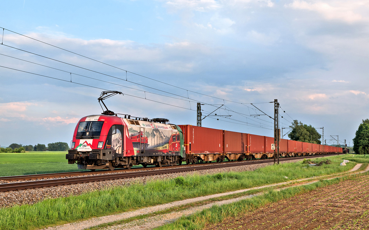 Die 1116 159 fährt am Abend des 10.5.2018 in Langenisarhofen mit einem Containerzug nordwärts.